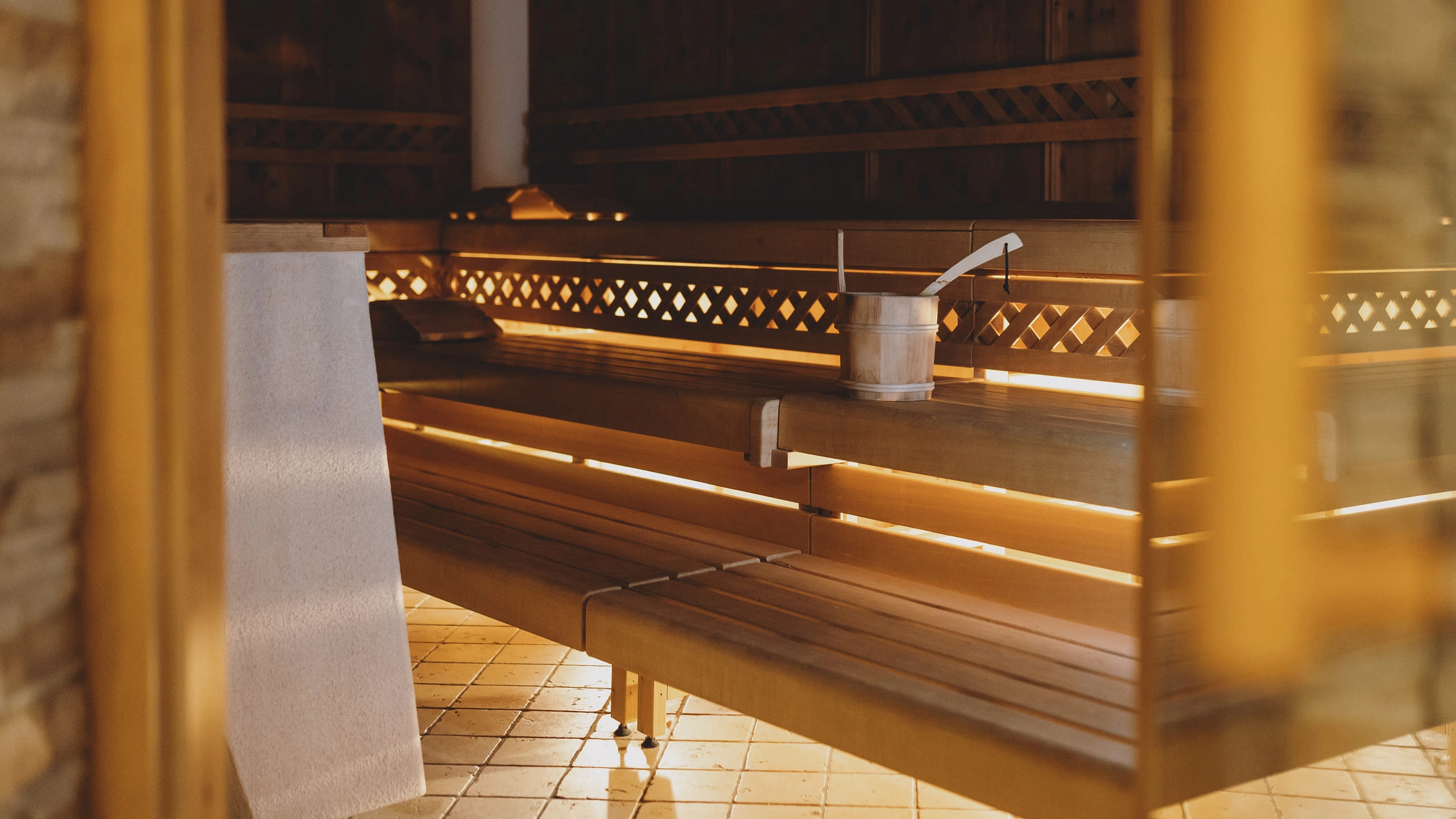 Innenansicht einer Sauna mit Holzbank und Eimer